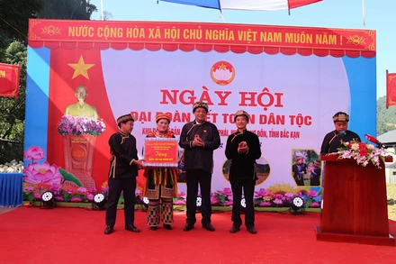 Phó Chủ tịch Quốc hội Trần Quang Phương tặng quà cho nhân dân Bản Cuôn. (Ảnh: CÔNG LUẬN).