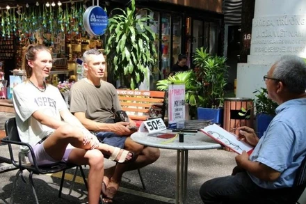 Khách quốc tế trải nghiệm dịch vụ vẽ tranh ký họa trên đường sách Nguyễn Văn Bình, điểm đến du lịch nổi tiếng khu trung tâm Thành phố Hồ Chí Minh. (Ảnh: Nguyễn Hằng/TTXVN)