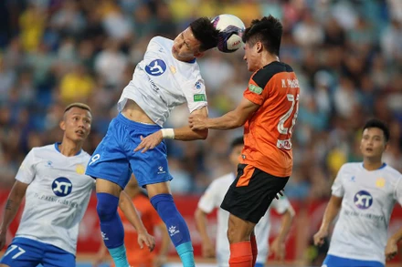 Pha tranh bóng quyết liệt giữa cầu thủ hai đội Nam Ðịnh (áo trắng) và SHB Ðà Nẵng. (Ảnh VPF) 