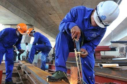 Công nhân thi công các hạng mục tại một công trình giao thông trên địa bàn thành phố Hà Nội. (Ảnh NGUYỄN ĐĂNG) 