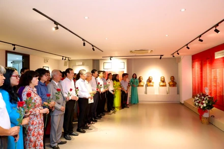Các đại biểu, khách tham quan dâng hoa tại khu tưởng niệm nhà báo liệt sĩ tại Bảo tàng Báo chí Việt Nam. 