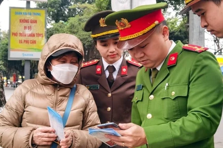 Ðoàn Thanh niên Công an TP Hà Nội phối hợp đoàn thanh niên phường, xã hướng dẫn người dân đăng ký tài khoản định danh điện tử phục vụ cho các thủ tục hành chính, bỏ sổ hộ khẩu. (Ảnh HOÀNG PHONG) 