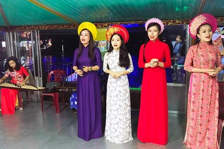 Các ca sĩ biểu diễn ca Huế phục vụ du khách trên sông Hương. 
