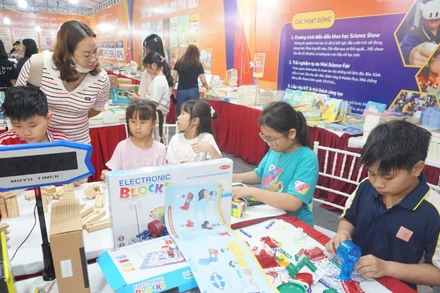 Các em học sinh trải nghiệm, sáng tạo tại gian hàng sách.