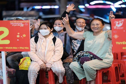 Người dân vui mừng trước khi lên “Chuyến xe hạnh phúc” để về quê đón Tết.