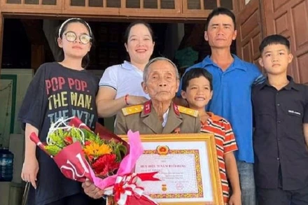 Cựu chiến binh Lữ Tấn Xa và các con cháu trong ngày ông nhận Bằng mừng thọ 95 tuổi do Hội Người cao tuổi địa phương trao tặng. (Ảnh: ĐÌNH TĂNG)