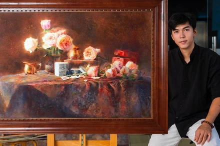 Họa sĩ Đoàn Quốc và một tác phẩm trong triển lãm lần này. (Ảnh: NVCC)