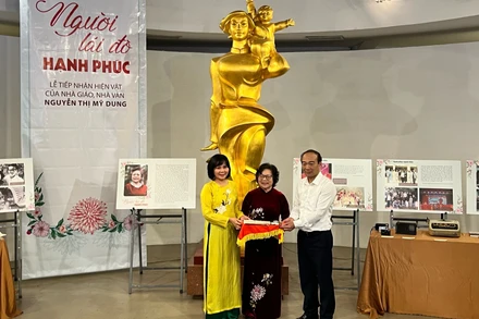 Đại diện Bảo tàng Phụ nữ Việt Nam tiếp nhận hiện vật từ nhà giáo, nhà văn Nguyễn Thị Mỹ Dung (người đứng giữa).