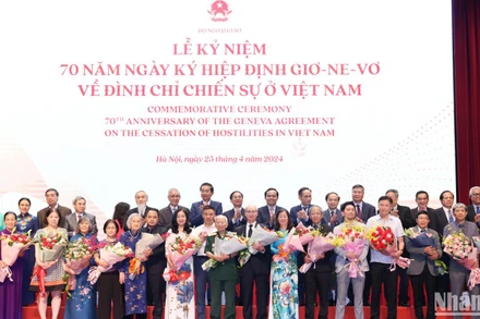 Trưởng Ban Đối ngoại Trung ương Lê Hoài Trung và Phó Thủ tướng Trần Lưu Quang tặng hoa, chúc mừng đại diện gia đình cán bộ tham gia phục vụ Hội nghị Geneve tại Lễ kỷ niệm.