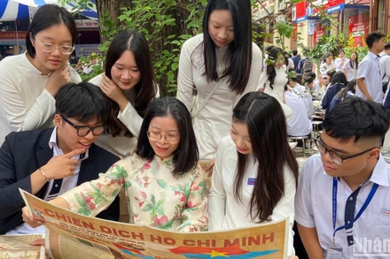 Cô và trò Trường trung học phổ thông Trần Phú xem phụ san đặc biệt về Chiến dịch Hồ Chí Minh của Báo Nhân Dân. 