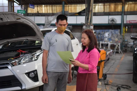 Chị Nit đang chỉ đạo nhân viên trong xưởng sửa xe của mình.