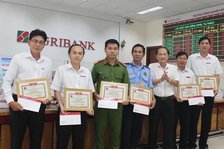 Trao giấy chứng nhận và tiền thưởng cho 6 cá nhân có thành tích bảo vệ tài sản của ngân hàng.