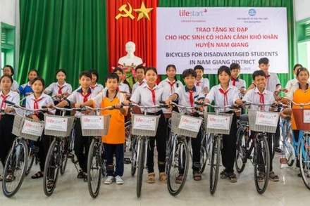 Các học sinh nghèo hiếu học tại huyện Nam Giang nhận xe đạp do Tổ chức phi Chính phủ Lifestart Foundation trao tặng. (Ảnh: ĐÌNH TĂNG)