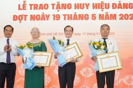 Chủ tịch Ủy ban nhân dân Thành phố Hồ Chí Minh Nguyễn Văn Được trao Huy hiệu 45 năm tuổi đảng cho các đảng viên. (Ảnh: LÊ VĨNH)
