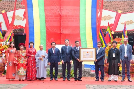 Thứ trưởng Văn hóa, Thể thao và Du lịch Hoàng Đạo Cương trao quyết định ghi danh “Lễ hội đền Hai Bà Trưng” vào danh mục Di sản Văn hóa phi vật thể Quốc gia cho đại diện lãnh đạo quận Hai Bà Trưng. (Ảnh: THẾ ĐẠI) 