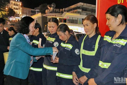 Đồng chí Trương Thị Mai trao quà Tết tặng các lao công đang làm việc trong đêm giao thừa tại thành phố Đà Lạt.