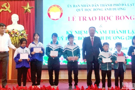 Chủ tịch Hội Khuyến học tỉnh Lâm Đồng Nguyễn Xuân Ngọc và Phó Chủ tịch UBND thành phố Đà Lạt Nguyễn Văn Sơn trao học bổng Ánh Dương tặng các học sinh.