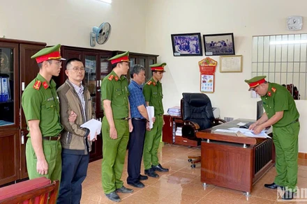 Cơ quan chức năng tống đạt quyết định khởi tố, bắt tạm giam bị can Lê Đình Thuần và Nguyễn Hữu Giảng. (Ảnh: H.Đ)