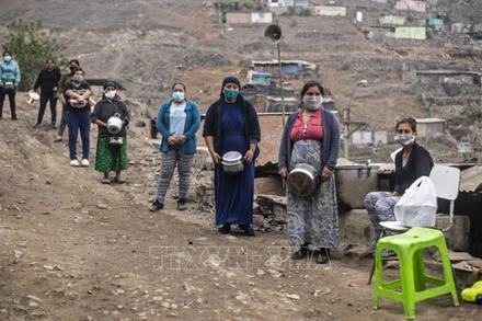 Ảnh minh họa: Người dân xếp hàng chờ nhận lương thực cứu trợ ở ngoại ô thủ đô Lima, Peru. (Ảnh: AFP/TTXVN)