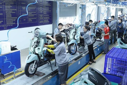 Công nhân làm việc tại dây chuyền lắp ráp của Công ty TNHH một thành viên xe điện DK Việt Nhật. (Ảnh: TTXVN)