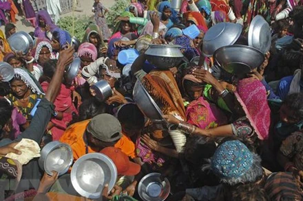 Ảnh minh họa: Người dân tập trung nhận lương thực cứu trợ tại khu vực chịu ảnh hưởng bởi lũ lụt ở tỉnh Sindh, Pakistan. (Ảnh: AFP/TTXVN)