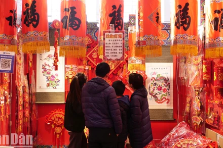 Một gia đình xem và mua tranh Tết.