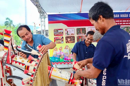 Các nghệ nhân huyện Trà Bồng, tỉnh Quảng Ngãi trang trí, tạo hình cây nêu của người Co. (Ảnh: ĐÔNG HUYỀN)