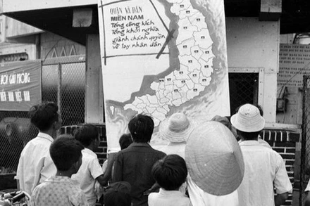 Nhân dân thị xã Phan Thiết (Bình Thuận) vừa được giải phóng theo dõi tin chiến thắng trên bản đồ chiến sự tại phòng thông tin thị xã (tháng 4/1975). (Ảnh: Mai Hưởng/TTXVN)