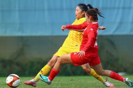 Huỳnh Như (áo vàng) tranh bóng cùng cầu thủ Than Khoáng sản Việt Nam. (Ảnh: VFF)