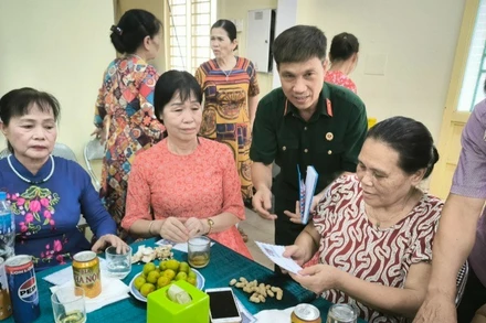 Cựu chiến binh Hoàng Văn Đạt (áo bộ đội) tặng quà các gia đình chính sách phường Đức Giang. 