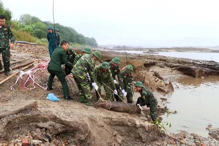 Lực lượng chức năng tiến hành di dời quả bom đi tiêu hủy.