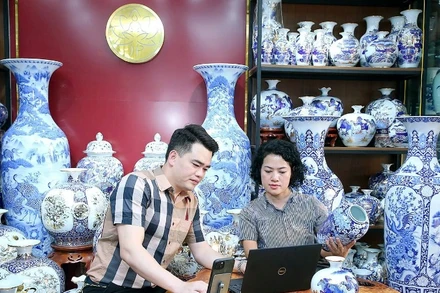 Nghệ nhân Trần Trung Hiếu (xã Bát Tràng, huyện Gia Lâm, Hà Nội) chia sẻ với đồng nghiệp về quy trình đưa sản phẩm lên sàn thương mại điện tử. (Ảnh HUY HOÀNG)