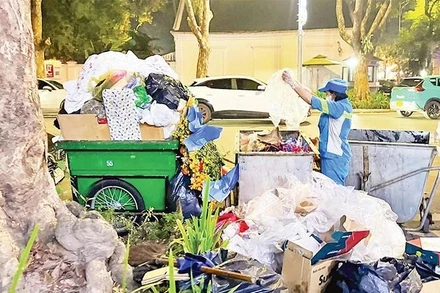 Công nhân Công ty Môi trường đô thị Hà Nội thu gom rác thải trên phố. (Ảnh: nhandan.vn)