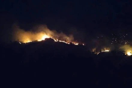 Lửa lan gây cháy trên khu vực đỉnh núi nên khó khăn cho các lực lượng chức năng và người dân tham gia dập lửa. (Ảnh người dân cung cấp)