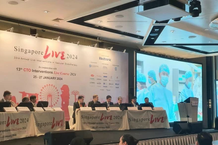 Các đại biểu tham dự Singlive 2024 tại đầu cầu Singapore đang theo dõi và bình luận ca can thiệp truyền hình trực tiếp từ Viện Tim mạch Việt Nam.