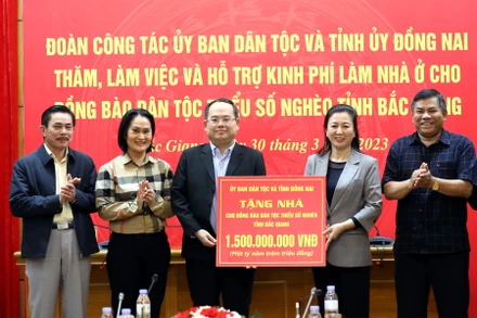 Phó Bí thư Tỉnh ủy Đồng Nai Quản Minh Cường trao bảng hỗ trợ kinh phí làm nhà ở cho đồng bào dân tộc thiểu số nghèo cho lãnh đạo tỉnh Bắc Giang.