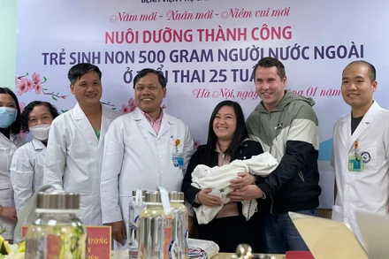 Niềm vui của gia đình chị Dung khi đón cậu con trai bé nhỏ từ tay PGS, TS Trần Danh Cường.