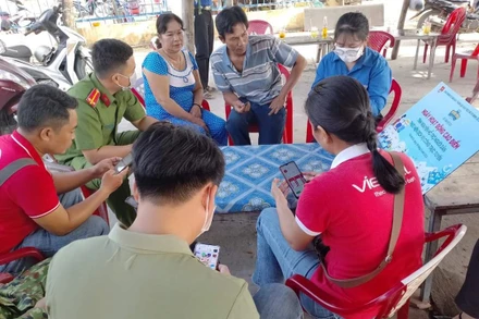 Đồng chí Thông tham gia hỗ trợ người dân thực hiện dịch vụ công trực tuyến.