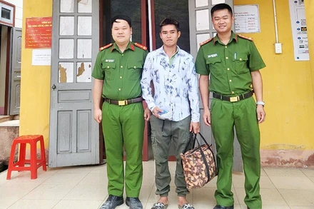 Anh Lý Nam Định (đứng giữa) nhận lại tài sản bị đánh rơi từ Công an xã Thượng Hà, huyện Bảo Yên, tỉnh Lào Cai. (Ảnh: QUỲNH TRANG)