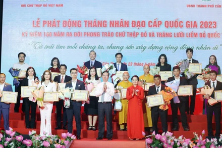 Chủ tịch nước Võ Văn Thưởng, Chủ tịch danh dự Hội Chữ thập Đỏ Việt Nam và bà Bùi Thị Hòa, Chủ tịch Hội Chữ thập Đỏ Việt Nam tặng hoa và trao bảng Ghi nhận tấm lòng vàng nhân đạo. (Ảnh: TTXVN) 