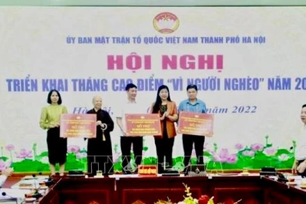 Mặt trận Tổ quốc Việt Nam thành phố Hà Nội trao kinh phí hỗ trợ hộ nghèo tại ba huyện Ứng Hòa, Mỹ Đức, Ba Vì. (Ảnh: TTXVN)