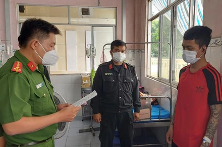 Công an tỉnh Đồng Tháp đọc lệnh bắt tạm giam đối tượng Phạm Hồng Qui. (Ảnh: Phước Thanh) 