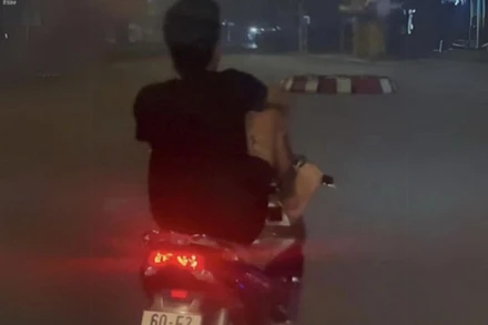 Võ Văn Tâm dùng chân điều khiển xe máy trên đường Hà Huy Giáp.