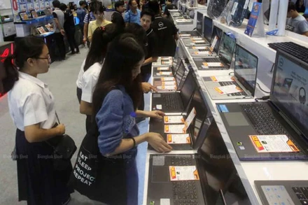 Các sinh viên đang tìm hiểu các loại máy tính xách tay trưng bày tại một hội chợ công nghệ. (Ảnh: Bưu điện Bangkok)