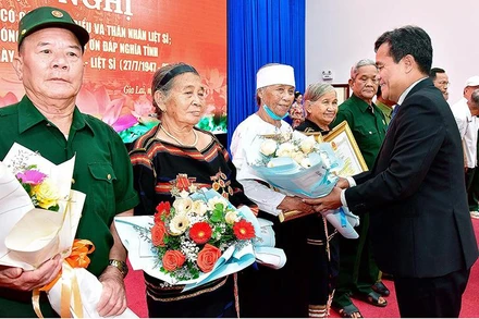 Bí thư Tỉnh ủy Hồ Văn Niên tặng hoa, bằng khen cho các đại biểu người có công và thân nhân liệt sĩ. (Ảnh: Đức Thụy)