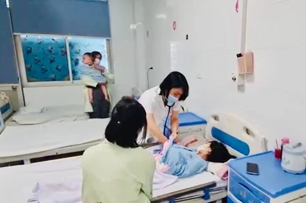 Bác sĩ bệnh viện Thanh Nhàn, Hà Nội thăm khám cho trẻ mắc sởi đang điều trị tại khoa Nhi của Bệnh viện. (Ảnh: ĐỖ THOA)