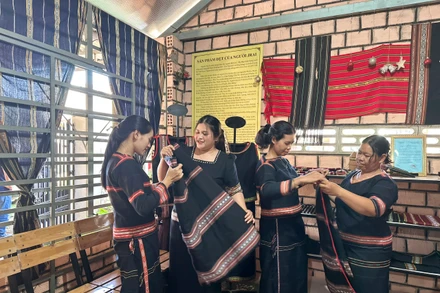 Các thành viên Câu lạc bộ dệt thổ cẩm làng Phùng trao đổi kinh nghiệm. (Ảnh THI PHONG)