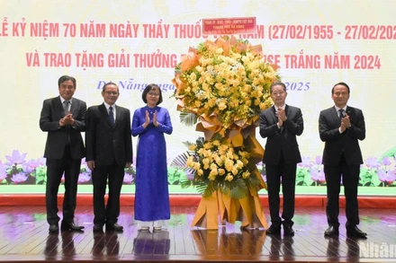 Đồng chí Nguyễn Văn Quảng, Ủy viên Ban Chấp hành Trung ương Đảng, Bí thư Thành ủy, Trưởng đoàn Đại biểu Quốc hội đơn vị thành phố Đà Nẵng và Phó Bí thư Thường trực Thành ủy Nguyễn Đình Vĩnh trao tặng lẵng hoa chúc mừng Ngành y tế Đà Nẵng nhân ngày 27/2. (Ảnh: ANH ĐÀO)