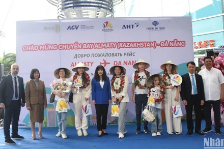 Những hành khách may mắn đầu tiên trên chuyến bay A330/300 đón nhận những phần quà ý nghĩa từ Sở Du lịch Đà Nẵng và các đơn vị liên quan. (Ảnh: ANH ĐÀO)