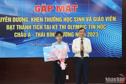 Chủ tịch UBND thành phố Lê Trung Chinh tặng Bằng khen và tiền thưởng cho học sinh Lê Ngọc Bảo Anh. (Ảnh: ANH ĐÀO)